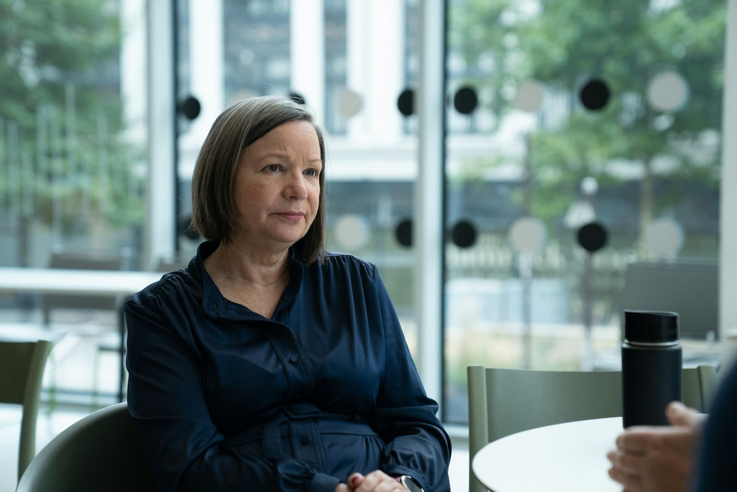 A senior executive listening attentively in a modern glass building