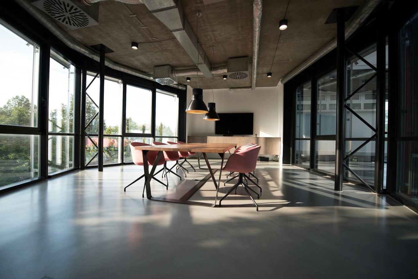 A high-floor meeting space with red chairs and floor-to-ceiling windows